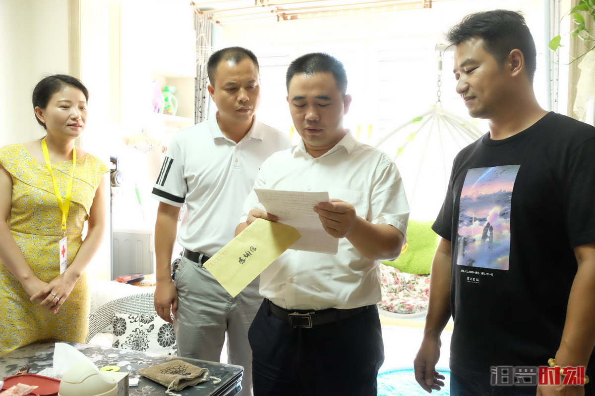 姚书茂(右二)正在读受捐者写给彭亮(右)的感谢信